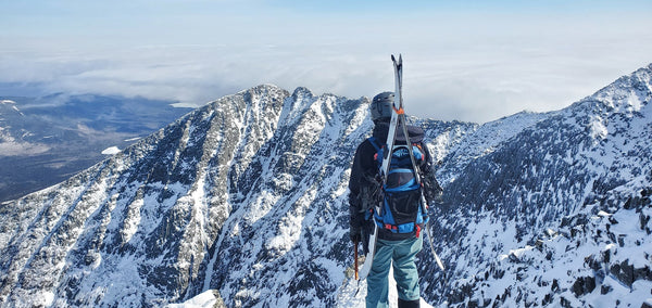 Skier atop Mt Katahdin looking at Chimney Couloir