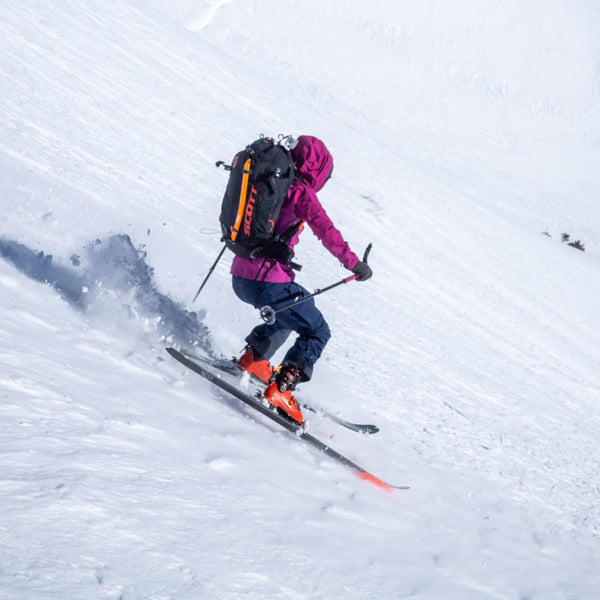 woman backcountry skiing with backpack and ice axe