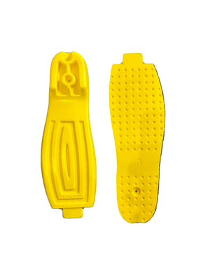 Two yellow plastic foot pedals on a gray textured surface