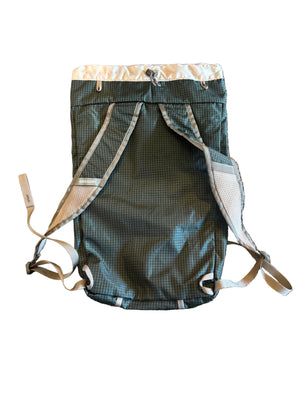 Green mesh bag with a strap on a textured surface