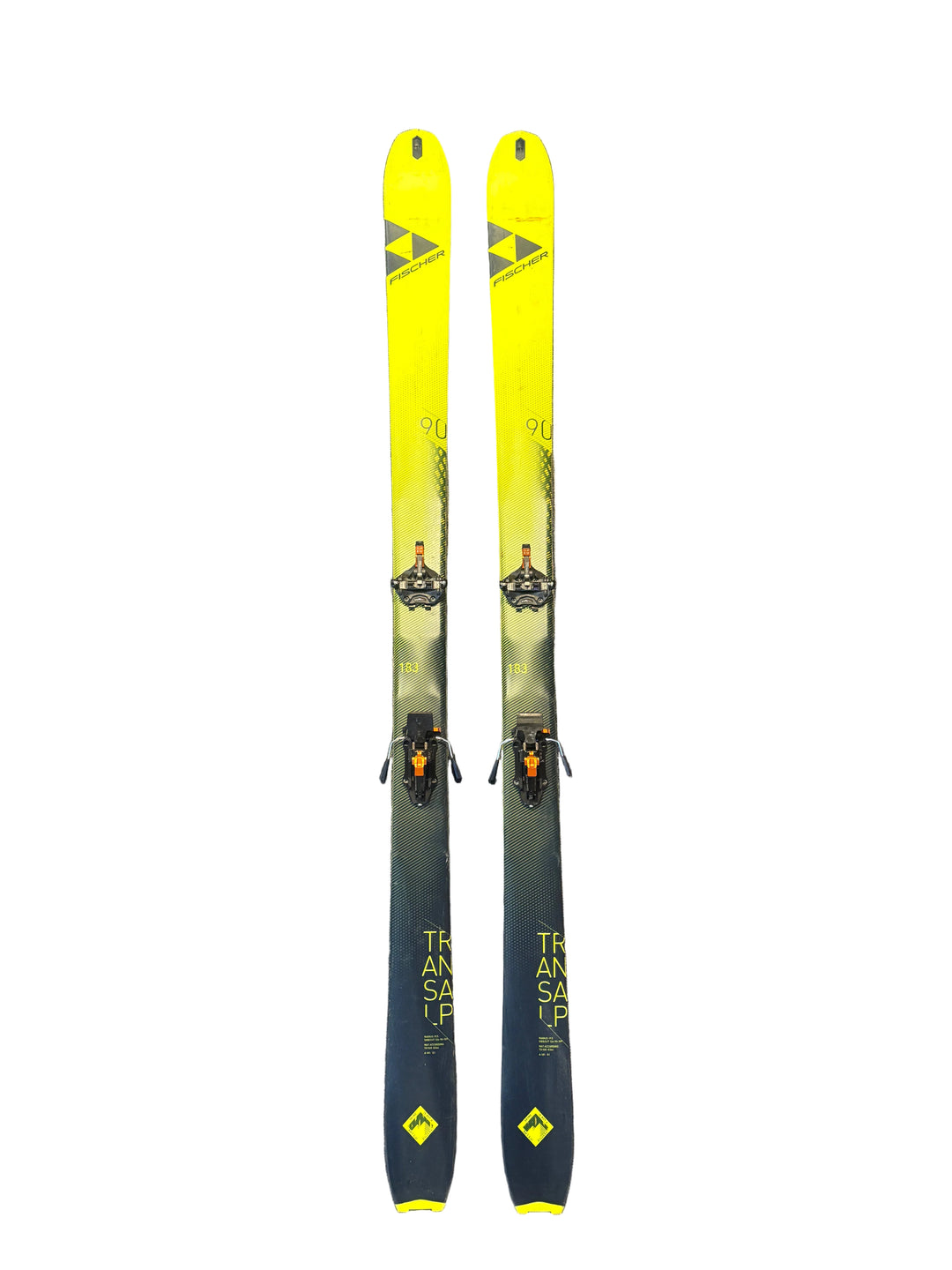 Two yellow and black skis on a gray carpeted floor.