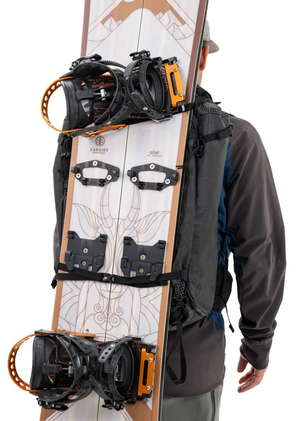 Person wearing a backpack with a snowboard attached, featuring a brand logo.