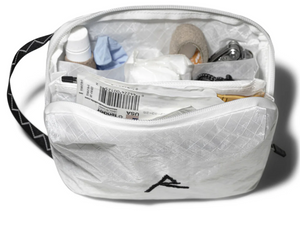 White toiletry bag with items inside on a white background